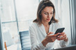 © SFIO CRACHO - Young business woman using mobile mobile phone at her workplace at modern office .Blurred background