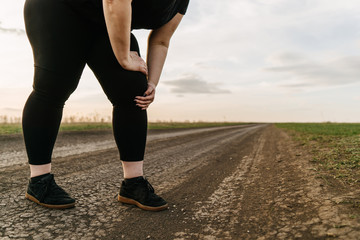 Wall Mural - Knee ache. Overweight woman touching paining leg. Joints overload, sports trauma.