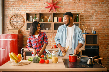 Canvas Print - Black man cooking on kitchen, wife drinks coffee