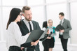 © yurolaitsalbert - business colleagues discuss business documents standing in the office