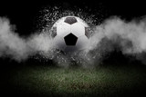 Fototapeta Sport - Traditional soccer ball on soccer field. Close up view of soccer ball (football) on green grass with dark toned foggy background