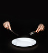 © Yegor - female hands with a knife and fork over a white plate on a white background