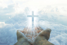 Hands Cupped With A Shining White Cross Hovering Above On A Sunny Blue Daytime Sky