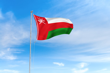 Wall Mural - Oman flag over blue sky background