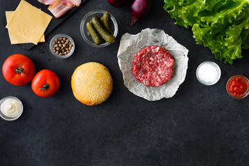 Wall Mural - Top view and flat lay of burger ingredients and sauce on black table with copyspace. Burger food background