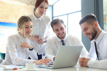 Group of business partners discussing ideas and planning work in office.