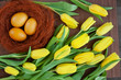  Jajka barwione kurkumą otoczone żółtymi tulipanami i brązowym sizalem