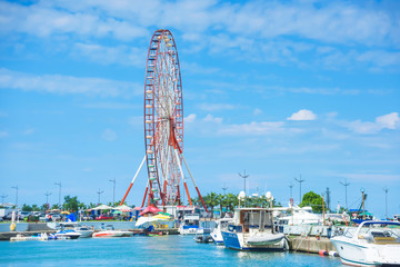 Ferris wheel against a cloudy sky . Walk along the promenade in Batumi. Ride the Ferris wheel. Rest in Georgia.