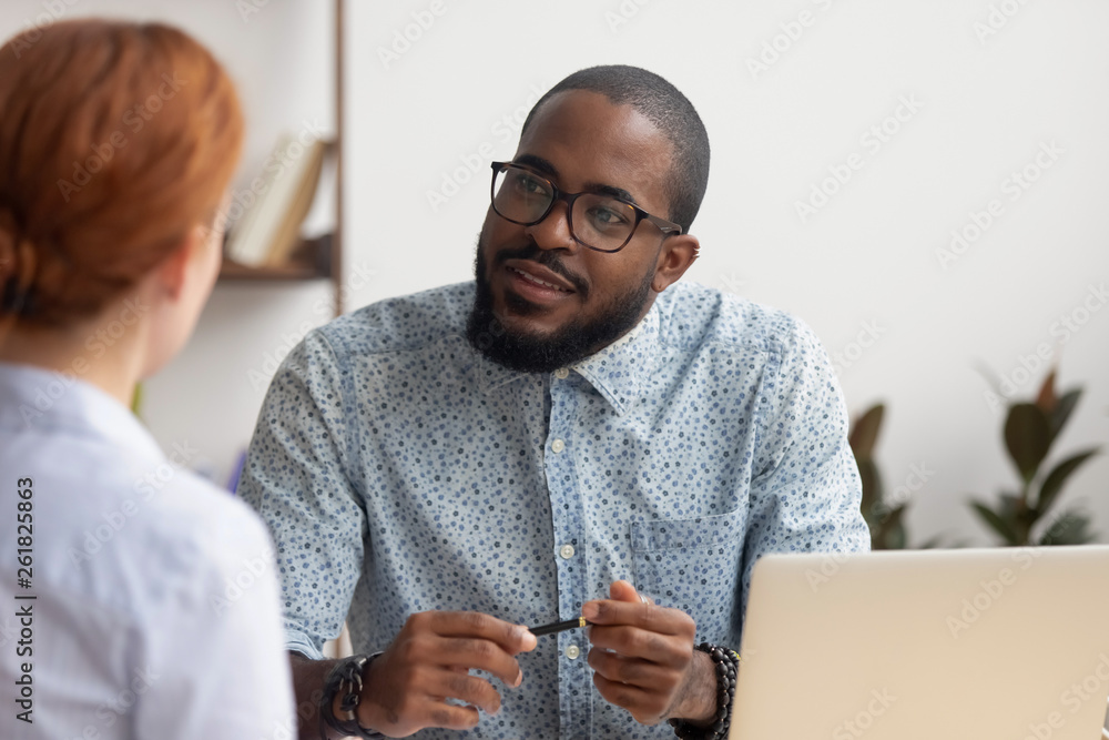African hr manager listening to caucasian applicant at job interview - obrazy, fototapety, plakaty 