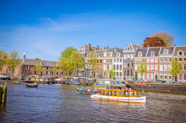 Wall Mural - Traditional old buildings and boats in Amsterdam, Netherlands. Canals of Amsterdam.