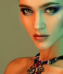 beautiful fashion model wearing elegant jewelry in color light