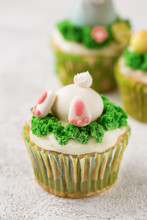Easter Cupcakes With Funny Bunny And Grass On White Background. Easter Holiday Concept