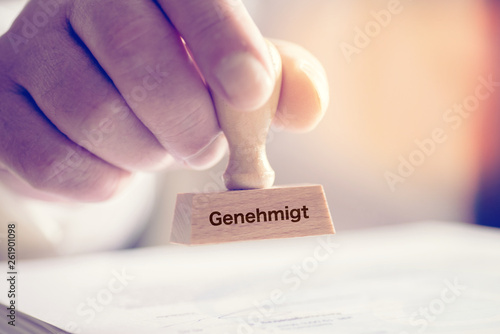 Fotografía Ein Mann und ein Stempel mit dem Aufdruck Genehmigt