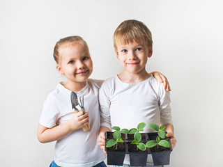 Two kids with sprouts and gardening tools, ecology theme on white background