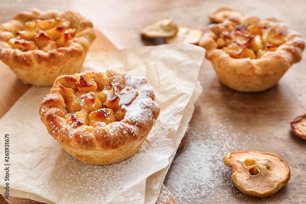 Tasty apple pies on wooden table