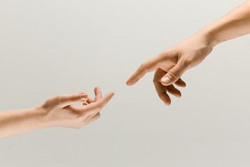 moment of weightless. two male hands trying to touch like a creation of adam sign isolated on grey s