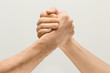 © master1305 - Friends greetings sign or disagreement. Two male hands competion in arm wrestling isolated on grey studio background. Concept of standoff, support, friendship, business, community, strained relations.