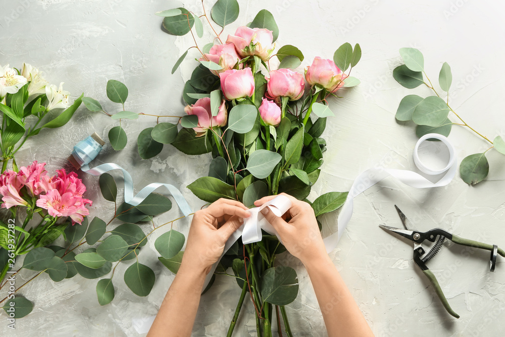 Florist making beautiful bouquet at table