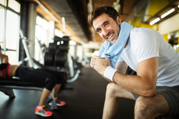 Lifestyle portrait of handsome muscular man after the training in the sport gym