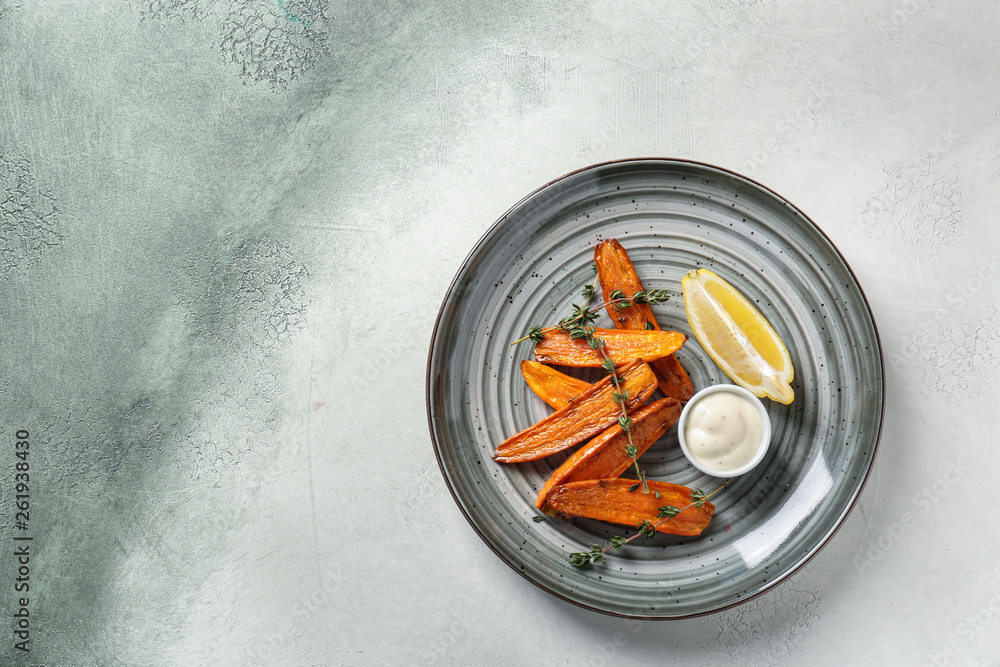Plate with tasty cooked carrot on light background