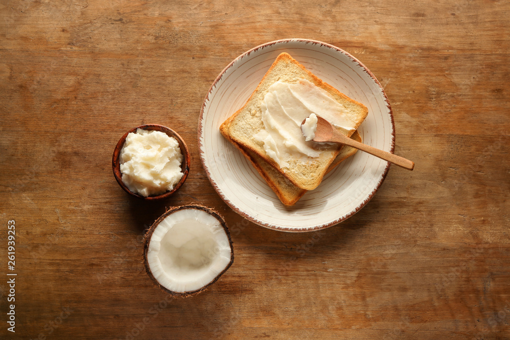 Coconut oil with tasty toasted bread on wooden table