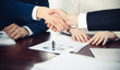 © rogerphoto - Business people shaking hands finishing up a meeting