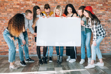 Joyful Millennials Holding Blank Whiteboard Mockup. Young People Laughing, Looking At Copy Space For Fun, Amusing Content.