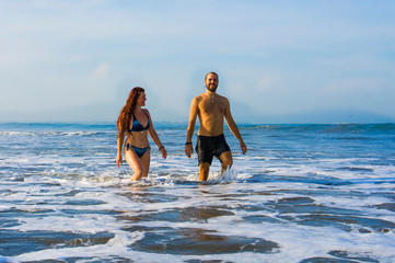 Wall Mural - happy and beautiful couple enjoying Summer holidays travel or honeymoon trip together in tropical paradise beach having fun relaxed and playful on the sea