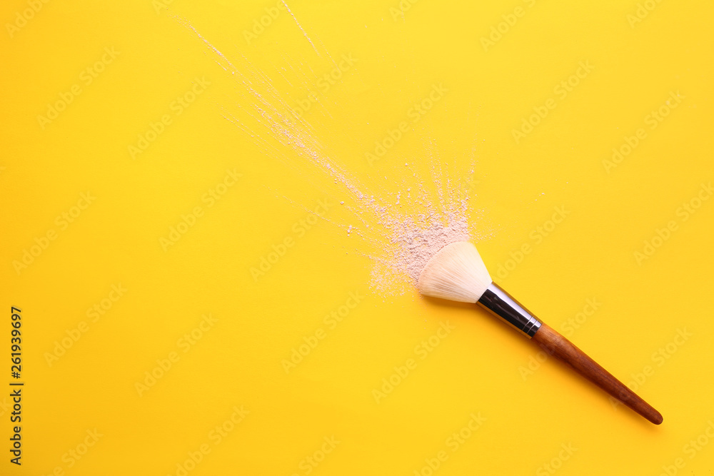 Facial powder and brush on color background
