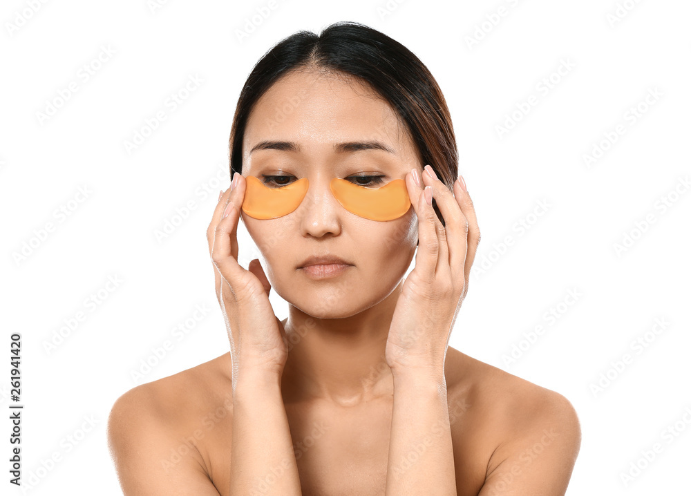 Asian woman with under-eye patches on white background