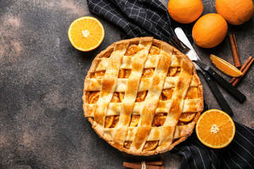 Tasty orange pie on grunge background