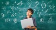 © bunditinay - Asian happy school boy thinking and holding laptop on black board background with hand-drawn doodles sketch.Creative education of kid student concept.