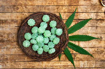 Wall Mural - Cannabis bonbons and marijuana leafs on a table