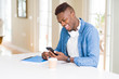 © Krakenimages.com - Handsome young african business man using smartphone smiling confident