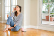 © Krakenimages.com - Beautiful young woman smiling confident and thinking positive sitting on the floor at home in the morning