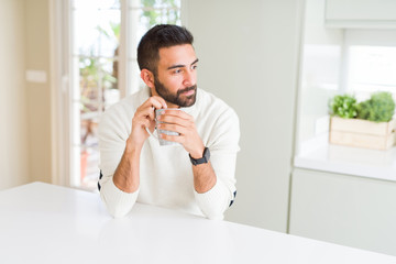 Wall Mural - Handsome man smiling while enjoying drinking a cup of coffee in the morning