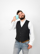 © epiximages - handsome, young man with black beard posing with turquoise coffee cup or tea cup in front of white background and making different facial expressions