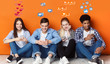 Teenagers with smartphones chatting in social networks, orange wall