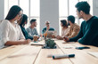 © gstockstudio - Staff meeting. Group of young modern people in smart casual wear discussing something while working in the creative office