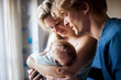 © Halfpoint - Beautiful young parents with a newborn baby at home.