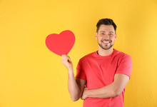 Portrait Of Handsome Man With Decorative Heart On Color Background, Space For Text