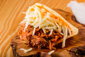 Roasted beef arepa on a wooden table