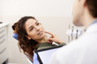 © Seventyfour - Portrait of beautiful young woman sitting in dentists chair and pointing at tooth while consulting with doctor, copy space