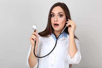 Wall Mural - Portrait of young doctor with stethoscope on grey background