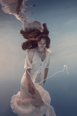 Portrait of a girl in a white dress under water