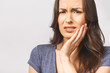 © denis_vermenko - Young European woman isolated on white background suffering from severe toothache, feeling pain so strong that she is pressing fingers to cheek to calm it down, looking desperate.