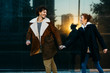 © Westend61 - Couple on a black wall with reflections running and looking at each other