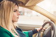 © andrey gonchar - Beautiful attractive sexy Scandinavian blonde with big blue eyes behind the wheel of a car - focused on driving - inexperienced driver