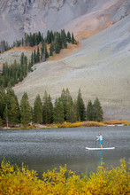 A Woman Paddle Boards On An Inflatable SUP At Alta Lakes Near Telluride, Colorado In Autumn In The San Juan Mountains.