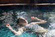 © Marc Romanelli - 12 year old girl face up and floating in heated pool, swimming, floating, face up